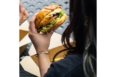 Woman holding a fast-food burger.